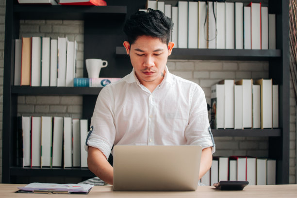 一个在家办公的人在桌上使用笔记本电脑图片下载