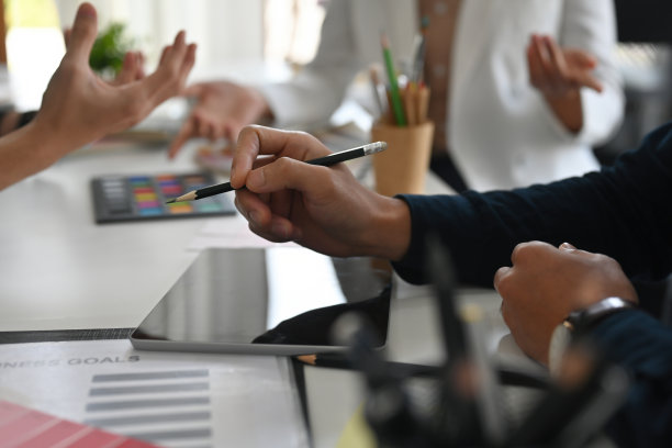 特写商务人士的手握笔，在办公室讲解和讨论工作内容，为艺术、设计、技术和商业理念。图片下载