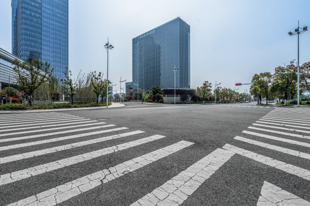 现代城市里空荡荡的马路上有斑马线和摩天大楼图片下载