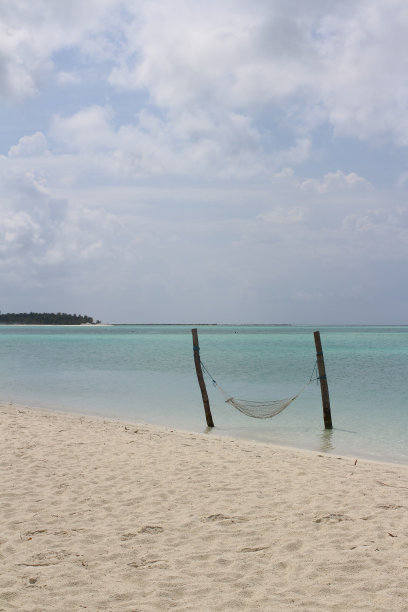 印度洋岸边的马尔代夫的早晨，白沙和吊床铺在蔚蓝的水面上图片下载
