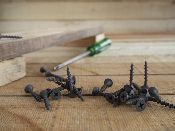 木制表面和木制背景上的自攻螺钉。图片下载