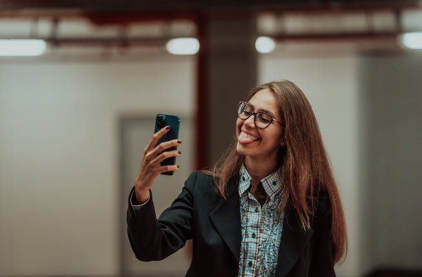 一个有吸引力的商务女性在西装公文包的社交网络与智能手机的照片。有选择性的重点。高质量的照片图片下载