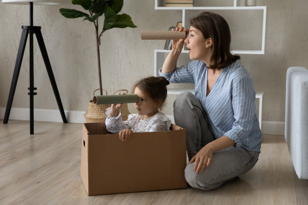 快乐的小女孩和慈爱的妈妈在家里玩有趣的游戏。图片下载