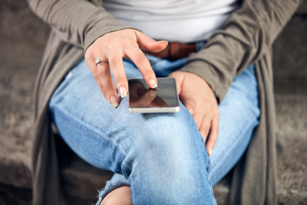 年轻可爱的女性在街上使用智能手机。图片下载