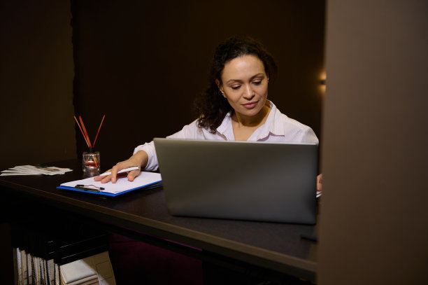 受到启发的女性室内装饰设计师规划家庭设计项目，在家具设计创意工作室附近与室内装饰面料样品站写笔记本电脑图片下载