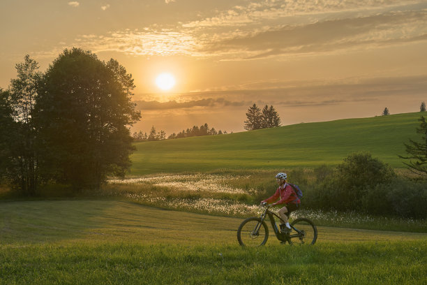 奥地利日落时骑着电动自行车的女人图片下载