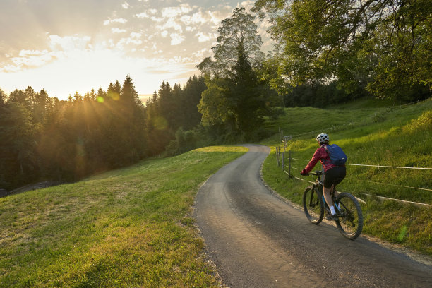 奥地利日落时骑着电动自行车的女人图片下载