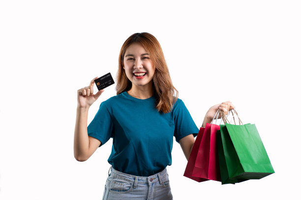 亚洲妇女持有购物袋与信用卡在白色背景图片下载