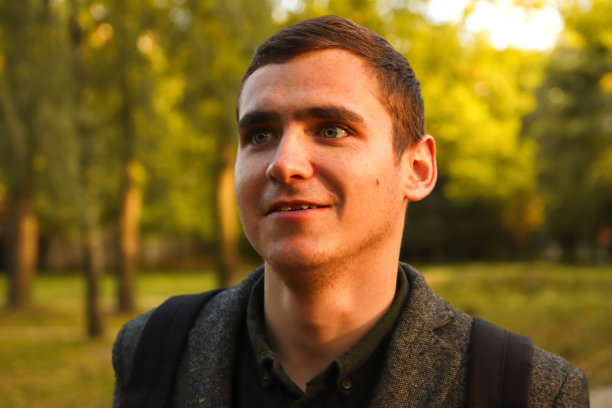 年轻人的肖像在自然秋天的背景。微笑的年轻人。20年。帅哥户外肖像。走在公园里。生活方式图片下载