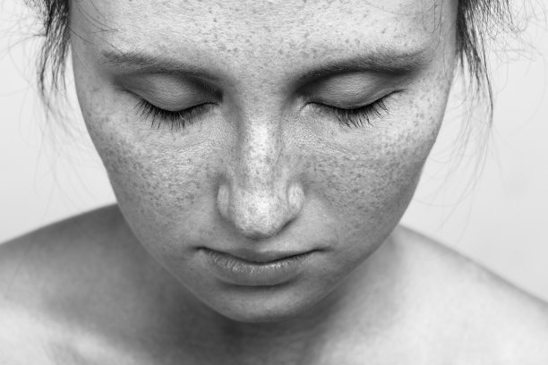 年轻女子带着雀斑自然美妆看特写肖像，单色图片下载