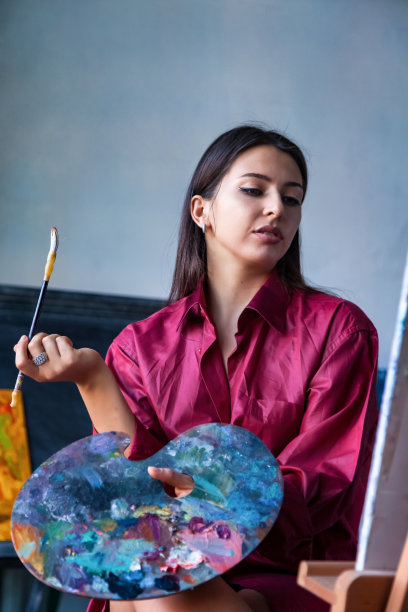 画家在家用水彩作画。在艺术工作室和画布上画漂亮的年轻女性艺术家的肖像图片下载