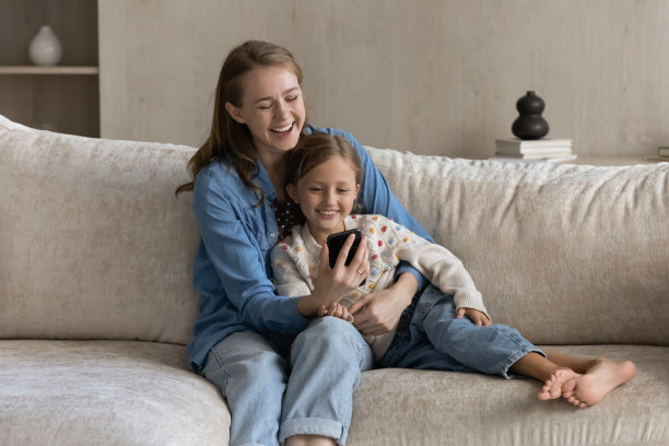 快乐的家庭在家里使用智能手机应用程序。图片下载