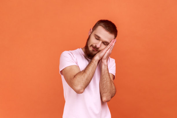 男人躺在她的手掌上睡觉，高兴地微笑着，舒服地打盹，打瞌睡。图片下载