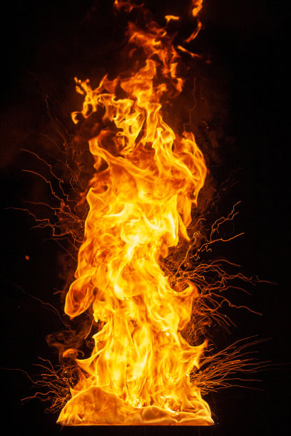 明亮耀眼的巨大火焰伴随着爆炸的粒子图片下载