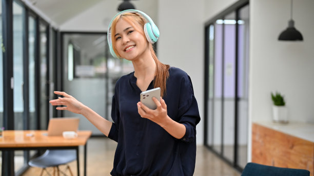 开朗美丽的亚洲千禧一代女性正戴着耳机享受音乐图片下载