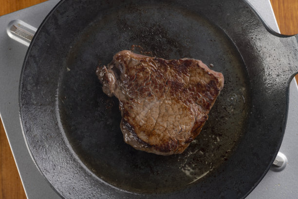 用铁锅烤牛排。图片下载