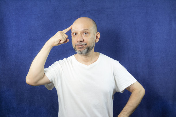 蓝色背景下一个大胡子男人的肖像。图片下载