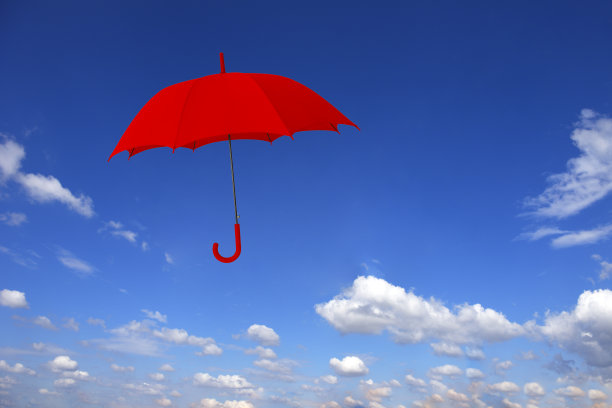 红色的伞在蓝天的映衬下漂浮在半空中图片下载