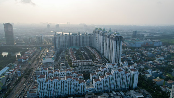 城市新绿城市景观鸟瞰图。城市景观的住宅区与现代公寓建筑日落时与噪音云。印度尼西亚雅加达，2022年6月23日图片下载