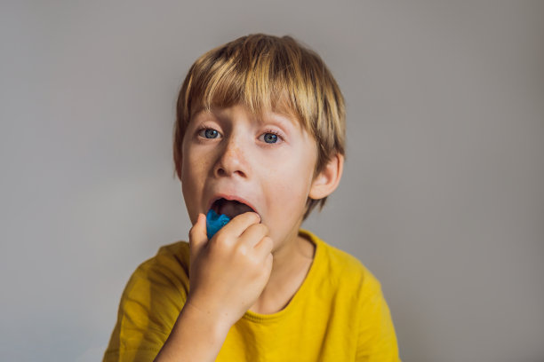 6岁男孩展示肌肉功能训练器。帮助平衡生长中的牙齿和正确的咬合，养成口腔呼吸习惯。矫正舌头的位置图片下载