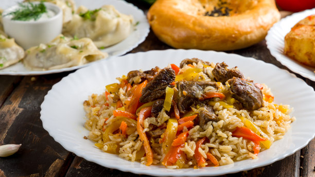 抓饭配牛肉和螳螂，木桌微距特写图片下载