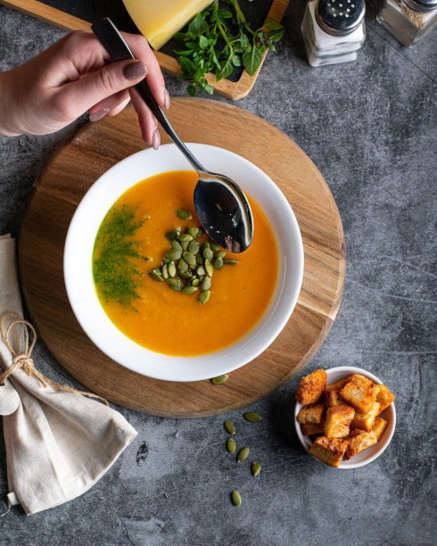 素食南瓜奶油汤泥，放在深棕色的木桌上，侧视图，特写。垂直图片下载