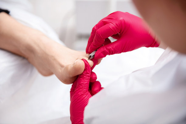 一个专业的医疗足疗程序的特写。Podologist的手与指甲钳的仪器。图片下载