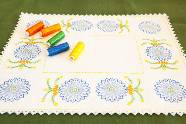 绣有矢车菊和线轴的餐巾，上面有刺绣和花边。刺绣作为一种创造性和针线活。图片下载