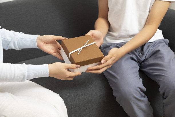 情侣爱一起送礼物的特写。年轻夫妇为周年纪念送礼盒。图片下载