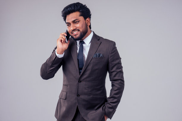 成功英俊的阿拉伯商人经典西装在白色演播室背景打电话图片下载