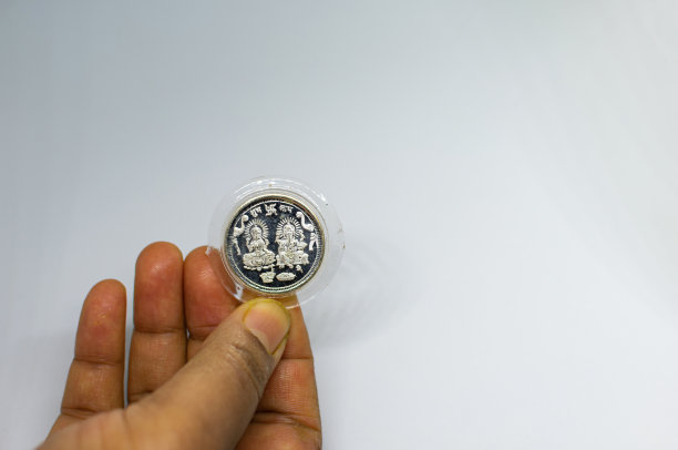 特写的一枚银币上刻有女神拉克希米和女神甘尼萨的形象在一个女人的手上。图片下载