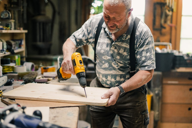 木工车间木工工人使用钻床工作图片下载