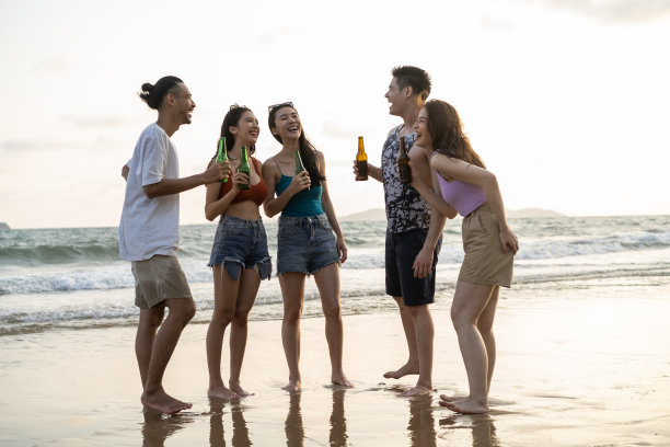 一群亚洲年轻男女在海滩上聚会。迷人的朋友唱歌、跳舞，在海边散步、跑步，在热带海岛享受假期度假之旅。图片下载