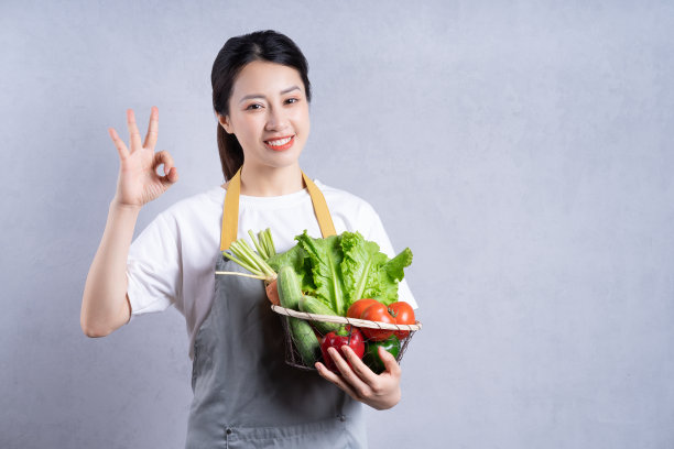 年轻的亚洲女人拿着蔬菜做背景图片下载