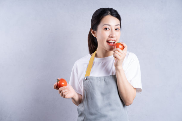 年轻的亚洲女人拿着蔬菜做背景图片下载