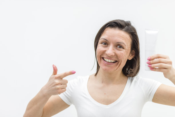 照片积极的女人手里拿着一个白色的背景奶油。图片下载