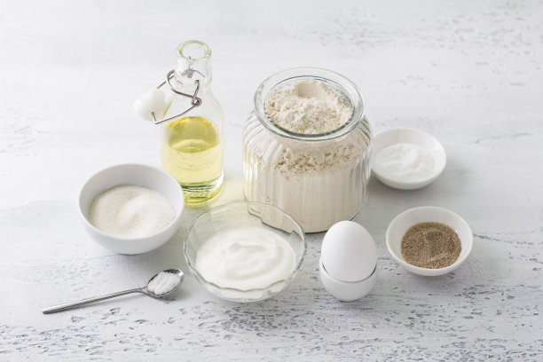 自制烘焙的原料:鸡蛋、酸奶油(酸奶)、糖、香草糖、面粉、植物油、泡打粉、淡蓝色底色的盐图片下载