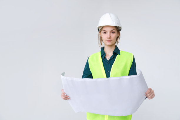 女建筑师在白色的硬帽子与图纸在白色的背景图片下载