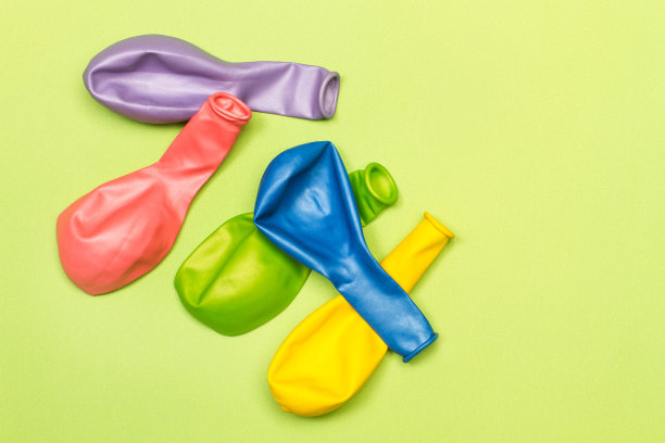 在绿色背景上放气的彩色气球图片下载