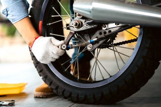 车库或车间的机械师在维修过程中检查经典摩托车的照片。图片下载