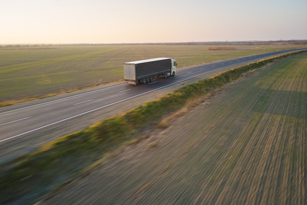 载着货物拖车的半挂车在公路上行驶的夜景鸟瞰图。配送运输和物流概念图片下载