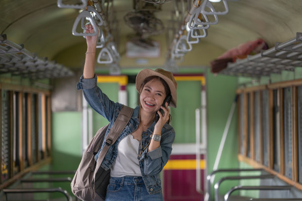 年轻的亚洲女性旅行者在火车上使用智能手机。图片下载