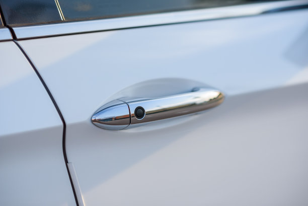 带有无钥匙感应的车门把手。不用钥匙就能自动打开车门。新款白色豪华轿车外观设计。特写镜头。图片下载