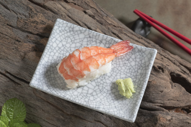 日本食物虾寿司盘上有筷子的木头背景。图片下载