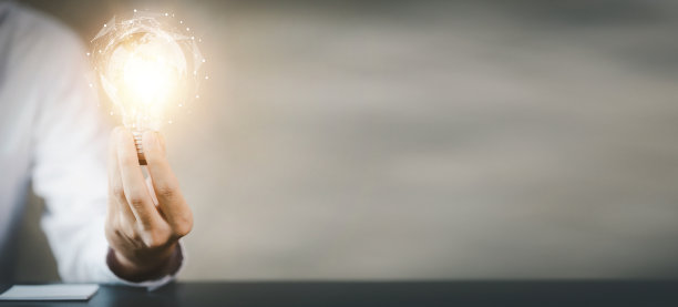 站在女人手里的灯泡，创造新的想法。创新，头脑风暴，制定战略，使业务增长和盈利。概念执行、战略规划、利润管理。图片下载