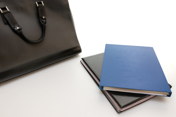 文件和一个黑色商务包在桌子上图片下载