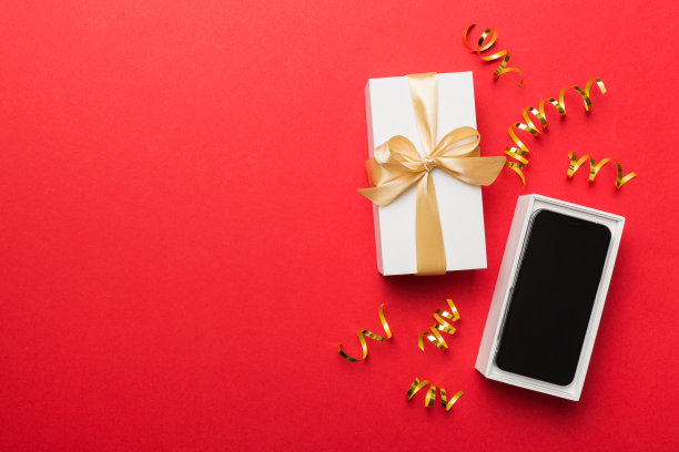 打开礼品盒，金色丝带和智能手机彩色背景，俯视图。空白开箱包装模型，模板为您的设计品牌模型图片下载