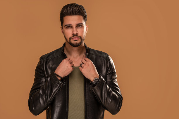 帅气时髦的年轻人穿着皮夹克看着镜头图片下载