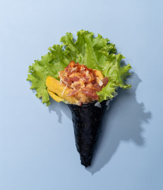辛辣的TAMAGO卷浇头与沙拉叶孤立的天蓝色背景俯视快餐图片下载