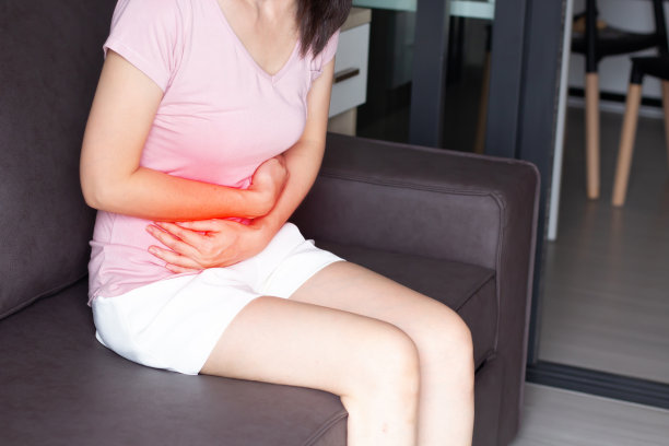 亚洲女性胃疼，用手交叉胃，感觉疼痛和发炎图片下载